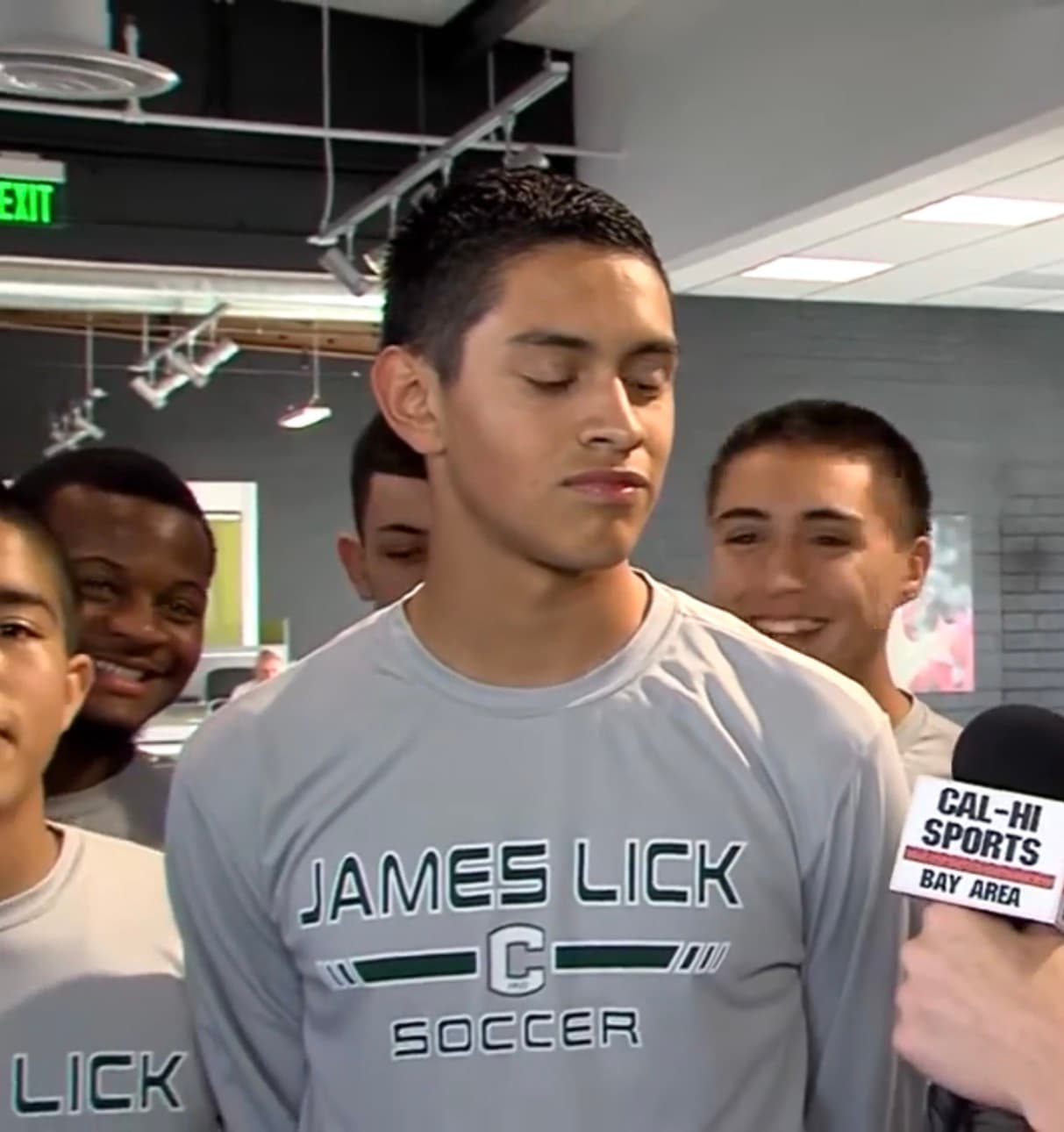 James Lick High School Soccer team shirt in the foreground with teammates visible behind during a Cal-Hi Sports TV interview.